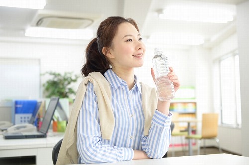 ペットボトルの水を飲む女性